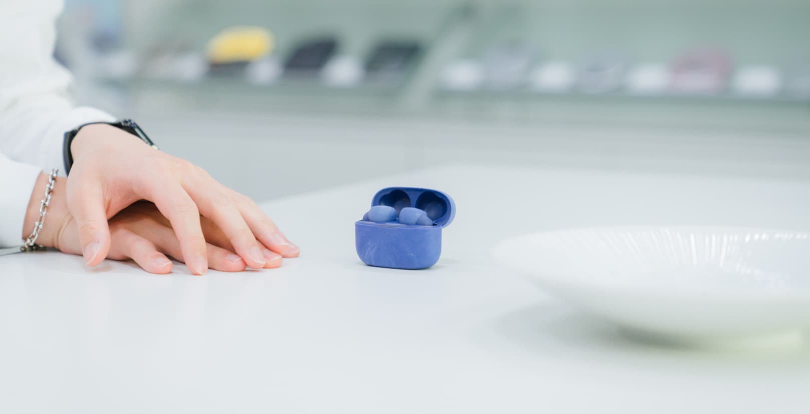 本坊健一郎さんの両手のアップとLink Buds Sの写真。