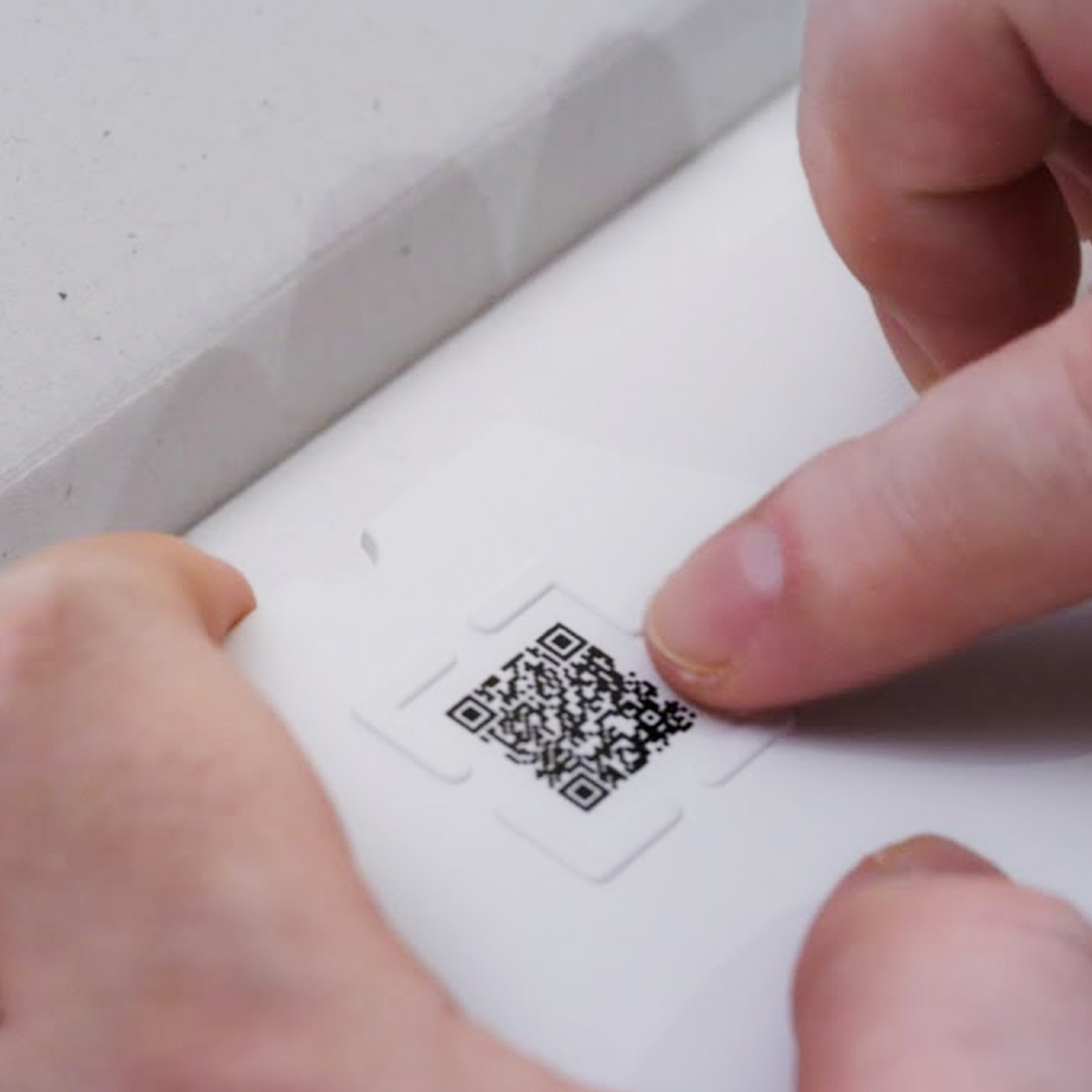 QRコードの周りの突起がある。突起を指で触っている。