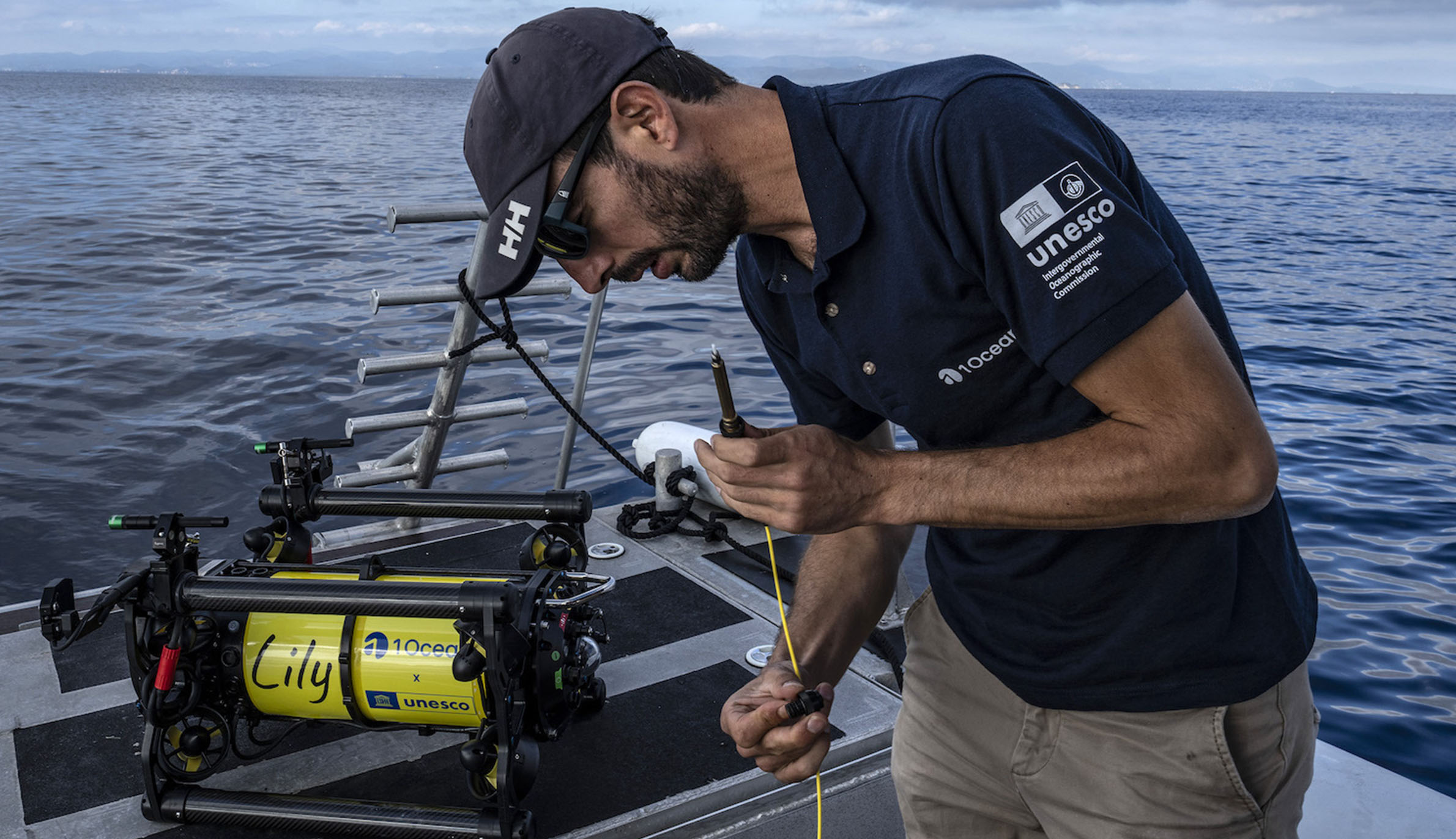 潜水撮影ロボット「リリー（Lily）」 にケーブルを取り付ける前に点検するアレクシス・ローゼンフェルド