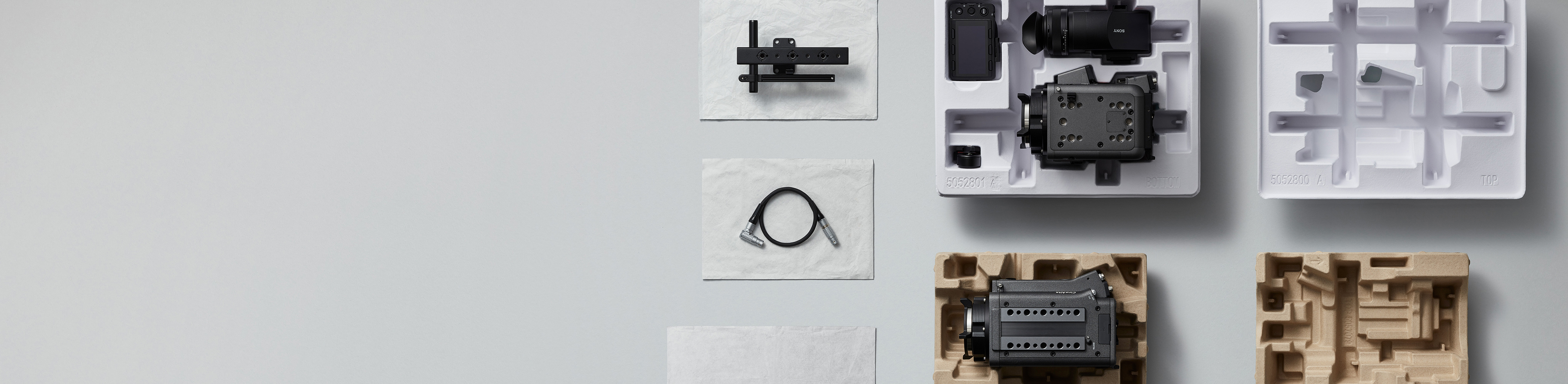 パルプモールド（紙素材を成型した緩衝材）と不織布製の袋、その上にのったさまざまなカメラ部品が並ぶ画像