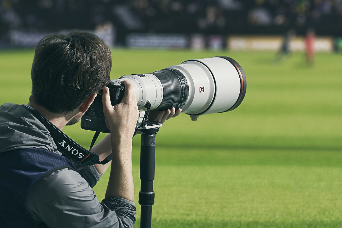 スタジアムで撮影する男性の後ろ姿