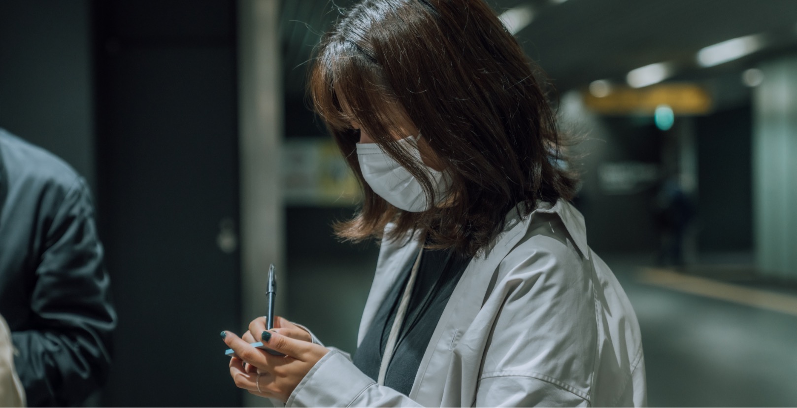 A person writing on a sticky note with a pen