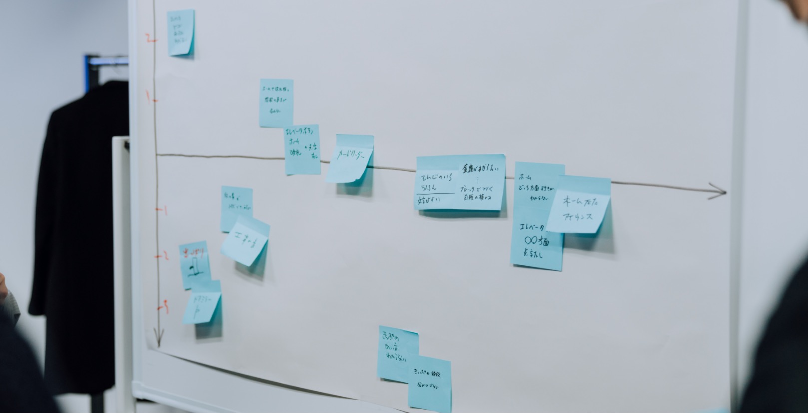 A person putting a sticky note in a wall.