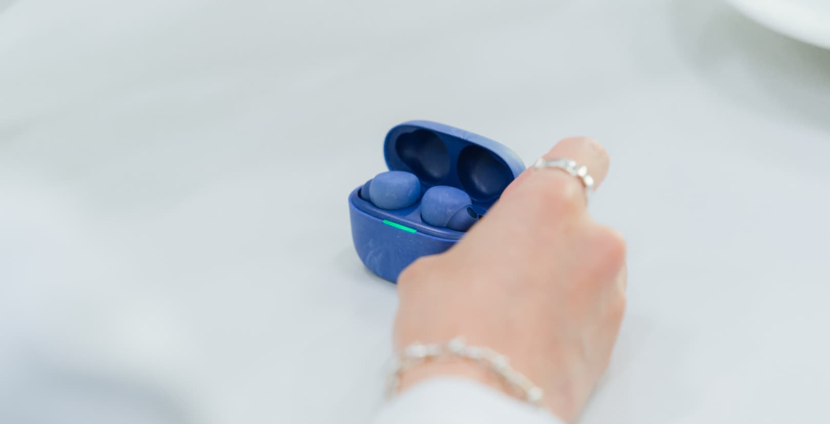 A male with sunglasses touching the price list at a ticketing booth in a train station.