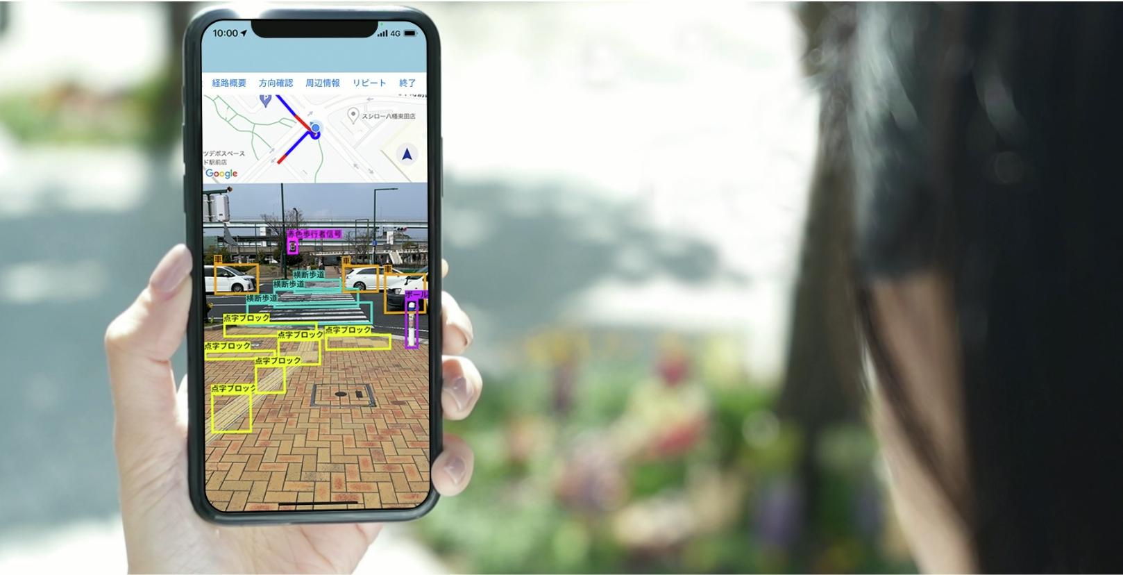 A person holding a phone whose display is showing EyeNavi app UI