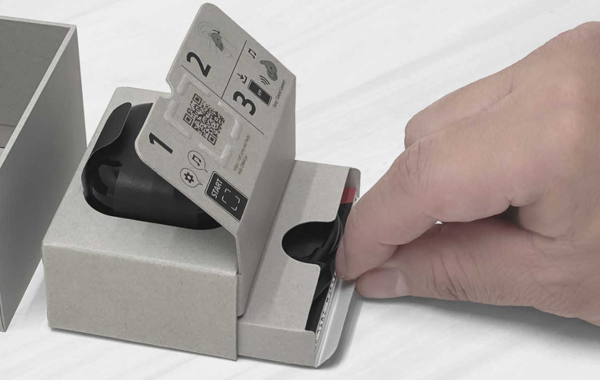 A close-up of the inner packaging removed from the Sony LinkBuds Open box. The bottom of the headset storage compartment has a drawer structure that can be pulled out by pinching and pulling on the tab.  There are accessories inside the drawer.