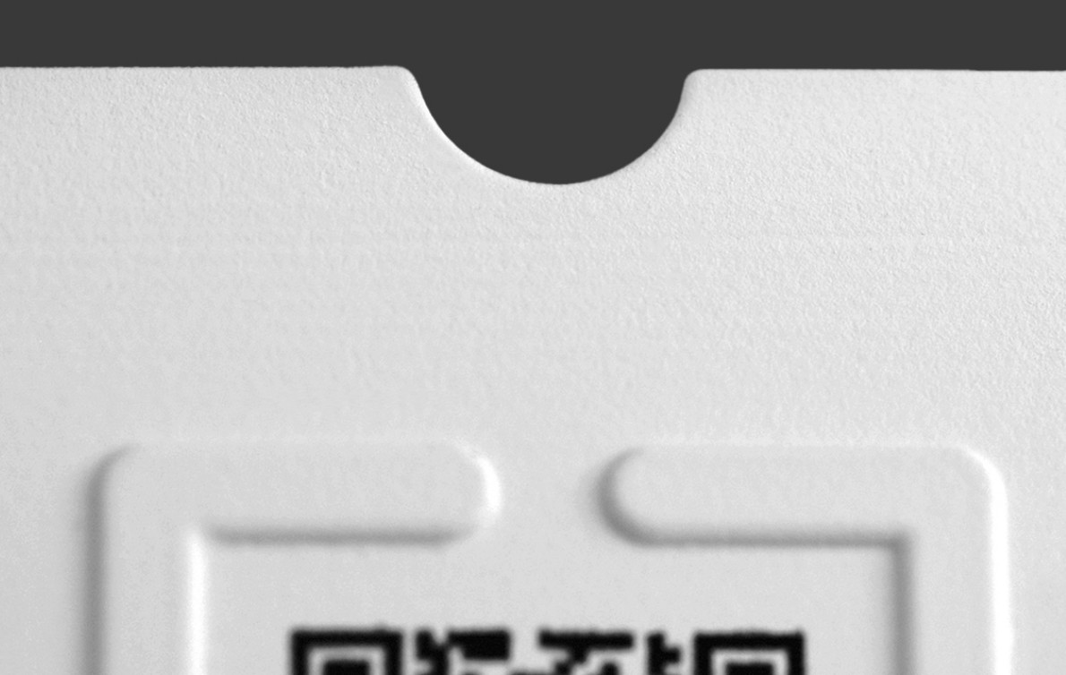 Close-up image of a semi-circular cut-out on the top edge of the page near the QR code.