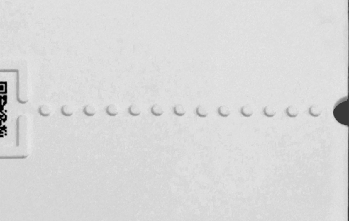 Image of the tactile dotted line leading from the cut-out on the edge of page to the QR code.