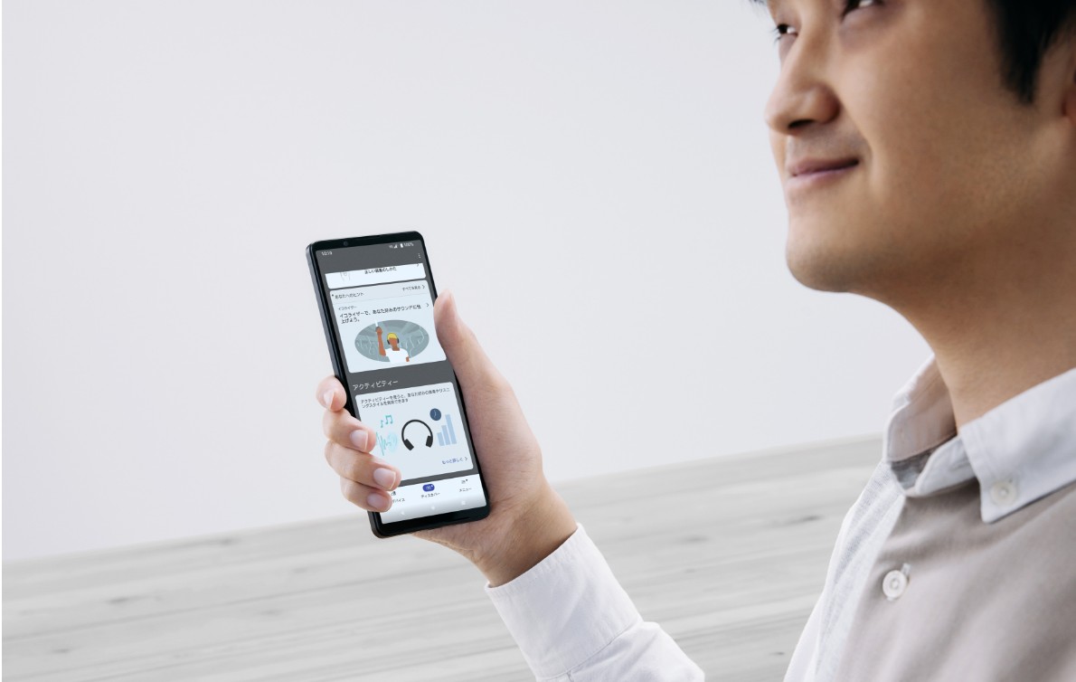 Close-up of a person holding a smartphone, smiling