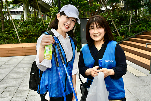 Two smiling participants after picking up trash