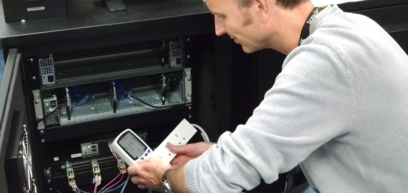 An employee is in front of the machine, using a tool to take measurements